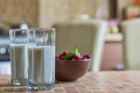 Glass of raspberry milk shake with berries on bright background Stock Photos