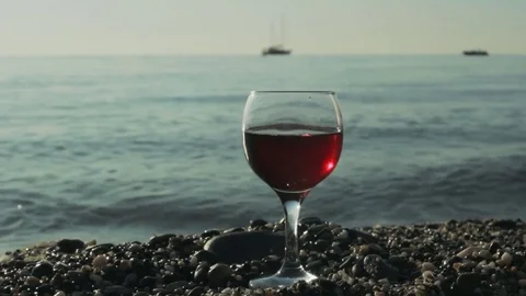 Glass of red wine on the beach Stock Footage 82336838