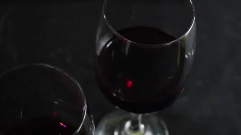 Glass of red wine on a dark background. Slow motion Vídeo Stock 163372987