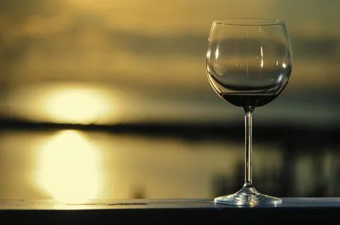 A glass of red wine in front of the setting sun Stock Photos