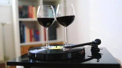 Glass of red wine swirling on the spinning gramophone record Video stock 275245341