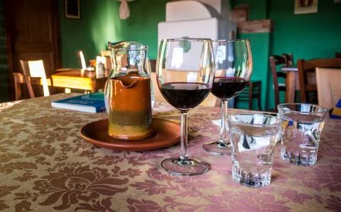 Glass of red wine on a table in rustic restaurant. Stock Photos