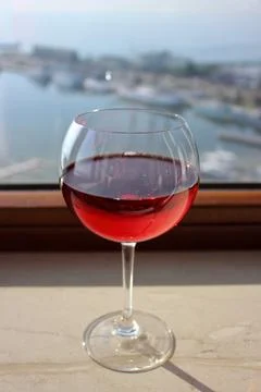 Glass of red wine by window Stock Photos
