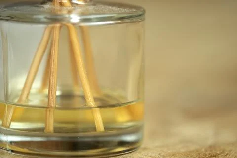 Glass reed diffuser with essential oil on wooden surface for wellness Stock Photos