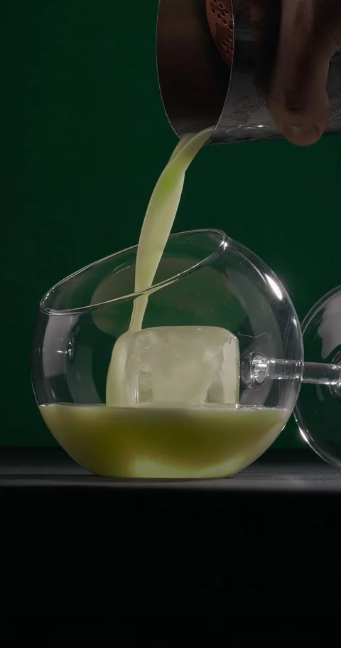 Glass of refreshing cocktail. Bartender pouring green cocktail Stock Footage 309865930