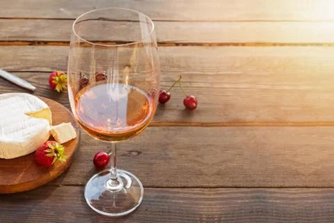 A glass of rose wine standing on rustic wooden table Stockfoto's