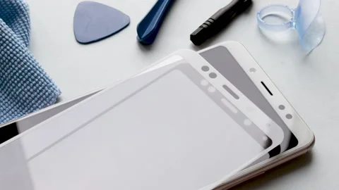 Glass screen protector holded above mobile phone, replace Stock Footage 194442965