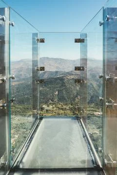 Glass skywalk overlooking mountain landscape Stock Photos