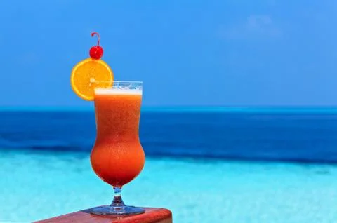 Glass of the soft drink is on a beach table (Maldives, The Indian Ocean) 스톡 사진