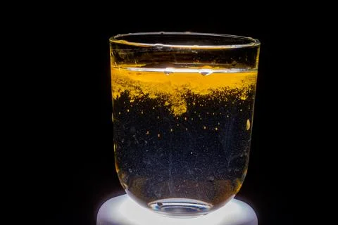 Glass of sparkling liquid with orange gradient Stock Photos