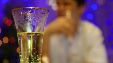A glass of sparkling wine. In the background the guy is drinking from a glass in 库存影片 71094022