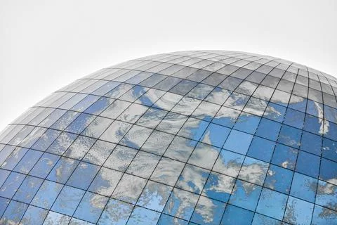 Glass spherical modern building with reflection of blue sky Stock Photos
