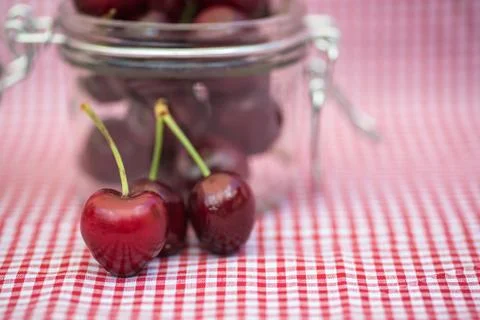 Glass storage jar full of fresh cherries Stock Photos