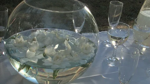 Glass table centrepiece with white flowers floating in water Video stock 95617054