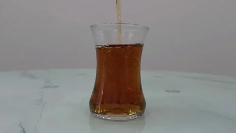 Glass of tea being poured on a reflective surface. Turkish tea Stock Footage 284043500