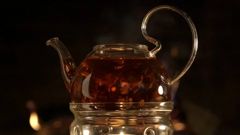 Glass tea pot with stand on fire background Stock Footage 101799452