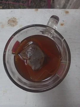 A glass of tea on a white surface Foto stock