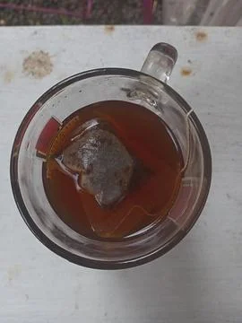 A glass of tea on a white surface Foto stock
