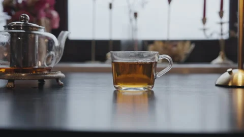 Glass teapot and cup of tea on black table Stock Footage 315958050
