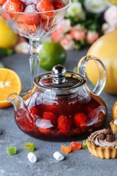 Glass teapot with fruit raspberry tea and mint on a blue background with frui Stock Photos