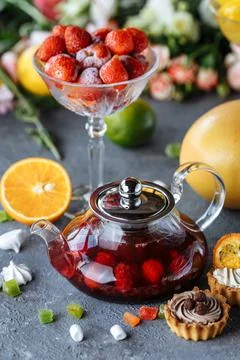 Glass teapot with fruit raspberry tea and mint on a blue background with fruits Stock Photos
