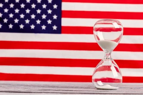 Glass timer with USA flag in the background. Foto stock