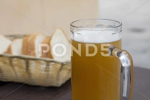 Glass of unfiltered beer and bread on wooden table Stock Photos