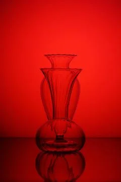 Glass vases on a red gradient background. Sharpness on the back of the vase. Stock Photos