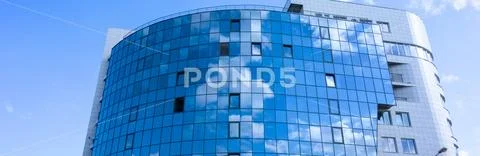 Glass wall facade with cloud sky reflection. Modern urban architecture backgr Stock Photos