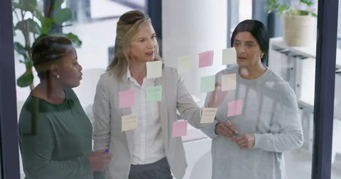 Glass wall, sticky note and business women in office for problem solving on Stock Footage 314055475