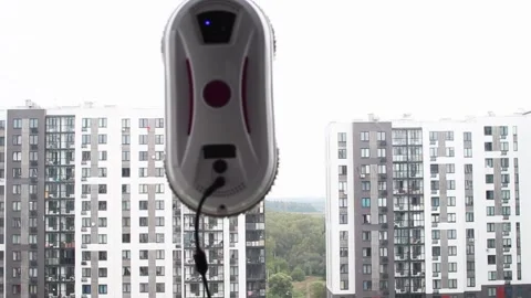Glass washer. A robot cleaner of a multi-storey building washes a window. Stock Footage 250956583