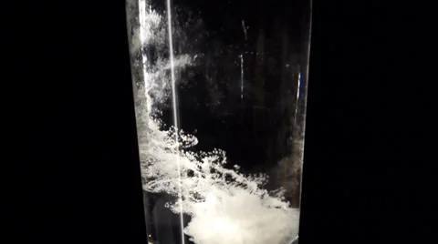 Glass of water and aspirin tablet in slowmotion Stock Footage