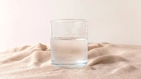 A glass of  water with a cube of ice inside it Stock Footage 146249610
