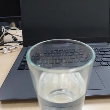 A glass of water prepared while working in front of a laptop Stock Photos