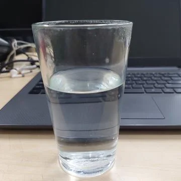 A glass of water prepared while working in front of a laptop Stock Photos