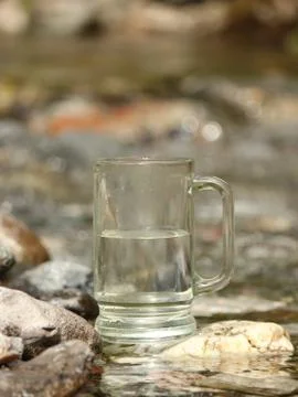 Glass of water at the source 스톡 사진