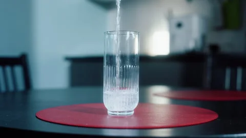 Glass of water on table in kitchen Vídeos de archivo 319441990