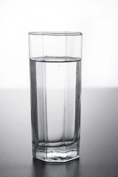 Glass of water on table with reflection. Stock Photos
