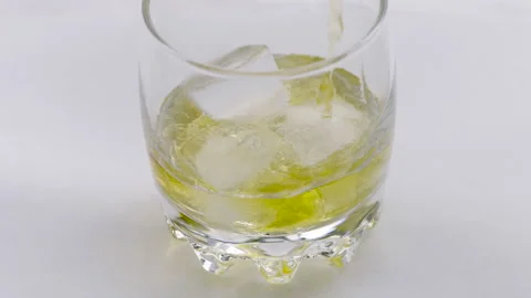 Glass of whiskey with ice cube. Stock Footage 239228617