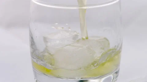 Glass of whiskey with ice cube. Stockbeeldmateriaal 239228729