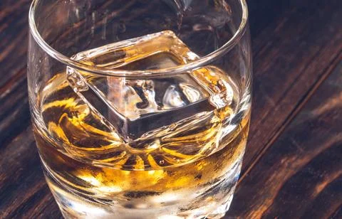 Glass of whiskey with ice cube Stock Photos