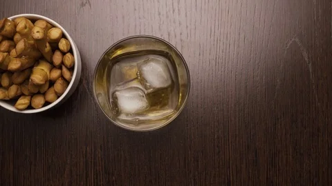 Glass of whiskey with ice put on the table, top view Stock Footage 73798422