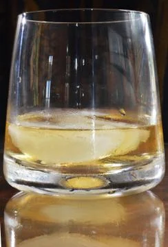 A glass of whisky reflected on the table Stock Photos