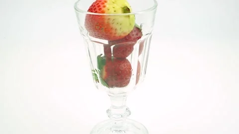 Glass on a white background. Strawberries falling into a glass Stock Footage 149136271