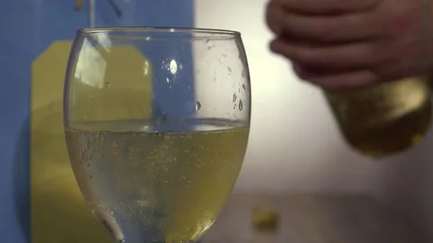Glass of white wine with serving hands in the background Stock Footage 188918401