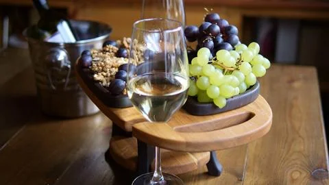 Glass of white wine sits elegantly against background of assorted fruits Wine Foto stock