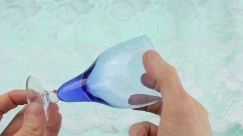 A glass of wine in the hands of inspection. Empty wine glass. Video stock 176965745