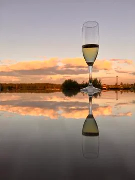 A glass of wine reflected in the mirror surface of the table Stock Photos