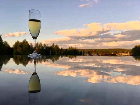 A glass of wine reflected in the mirror surface of the table Stock Photos