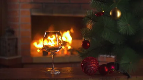 Glass of wine, Xmas tree, background - fireplace with flame. New Year alcohol. Stock-Footage 148075673